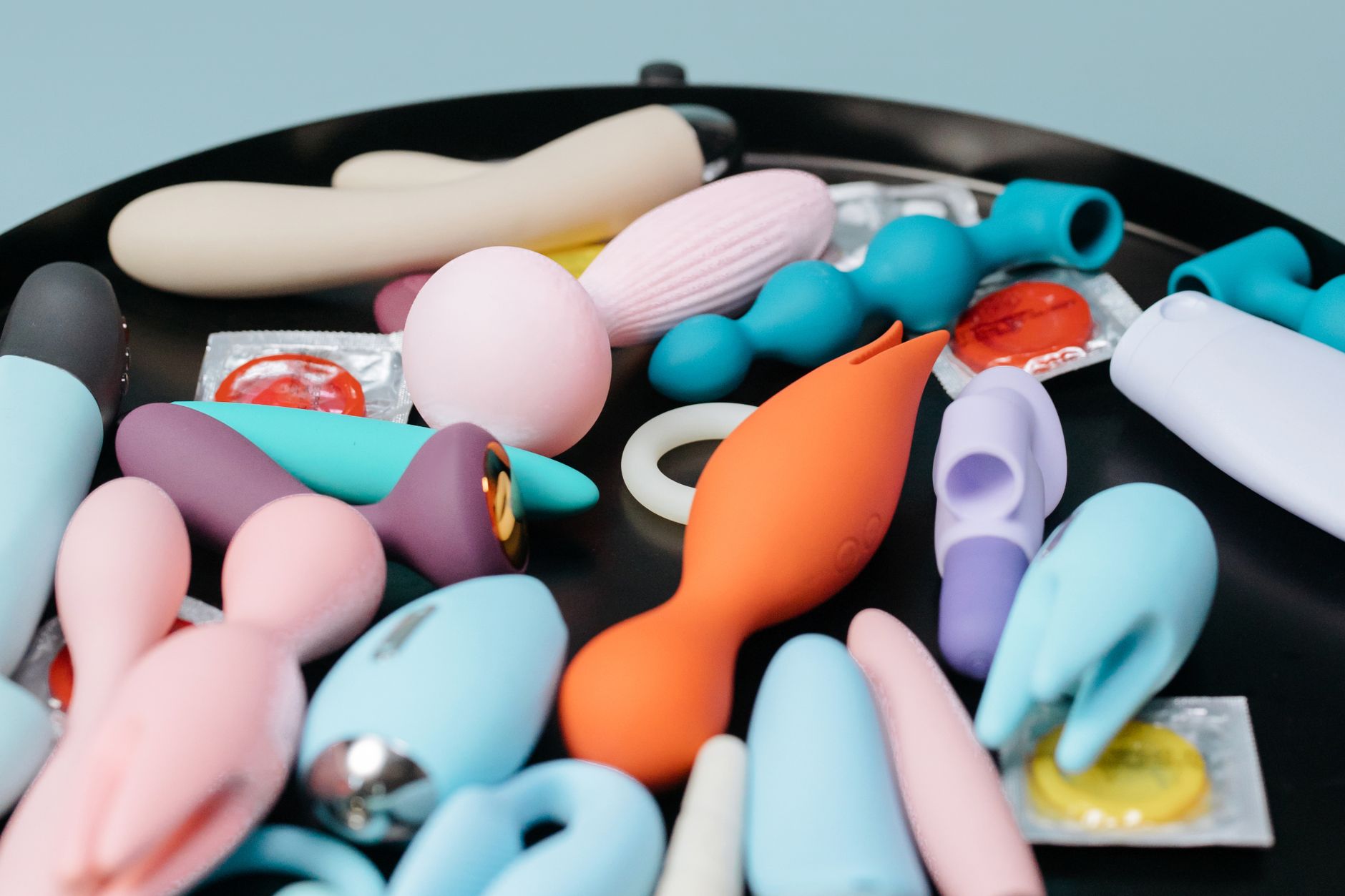 Ein blausilikon-Vibrator in der Hand vor violettem Hintergrund, Symbol für Selbstliebe und Sexualität