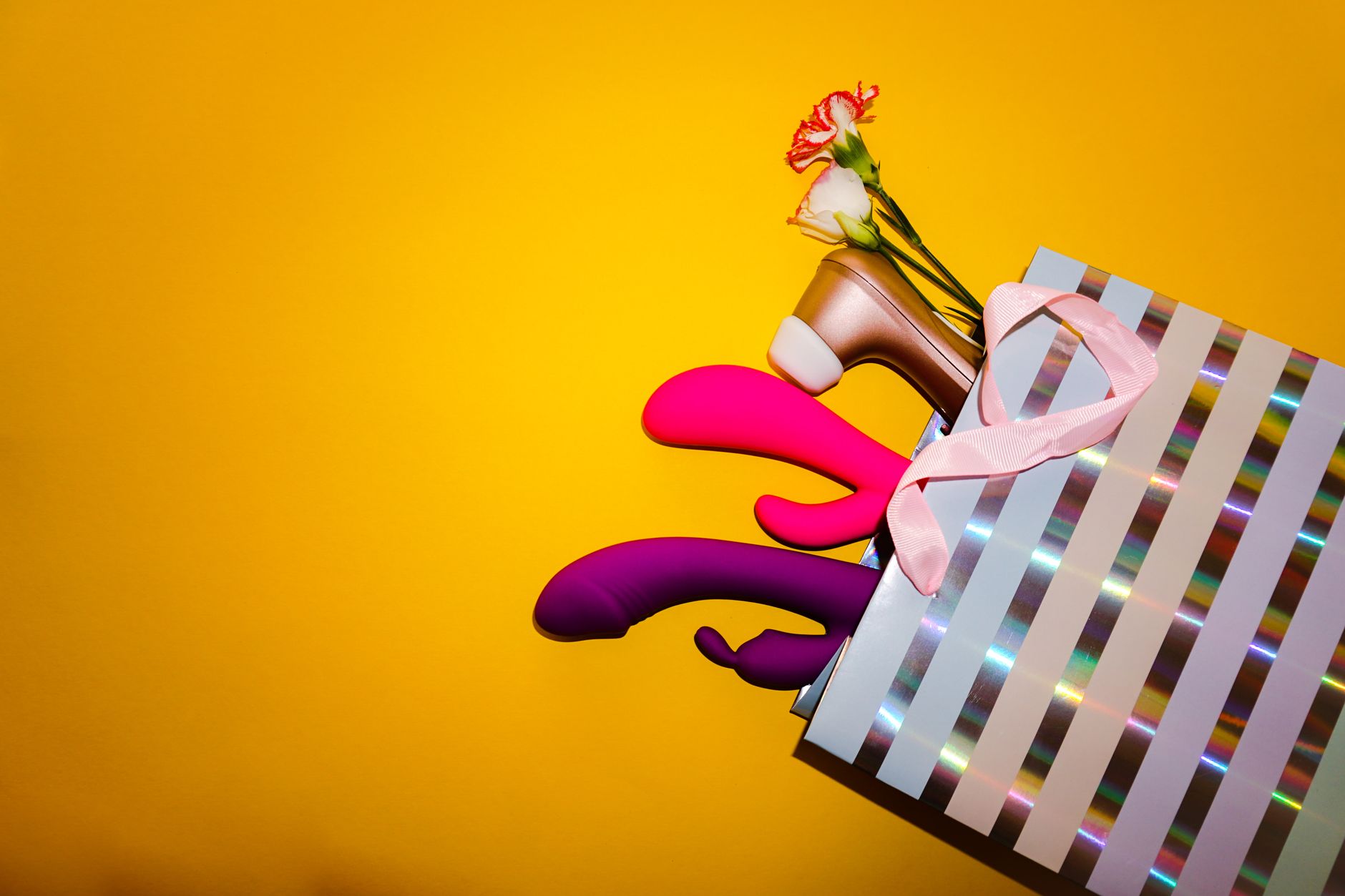 Bunte Zitronenvibratoren und Blumen in einer holopraphischen Geschenktasche auf gelbem Hintergrund