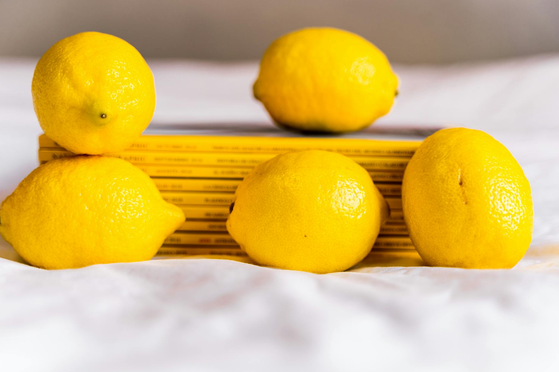 A yellow silicone vibrator surrounded by peeled bananas on a yellow background